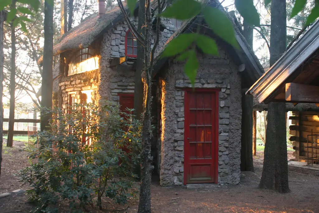 Pequeños templos de piedra con techo rojo entre árboles al atardecer