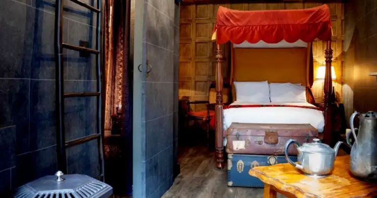 Dormitorio con cama de dosel rojo y decoración medieval en tema Harry Potter