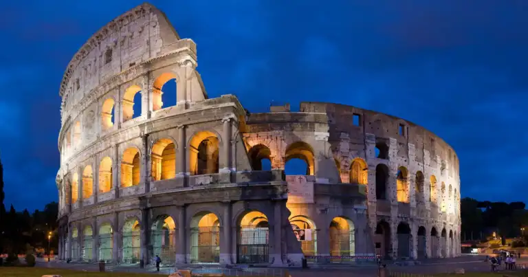 Coliseo antiguo romano iluminado al atardecer con arcos de piedra