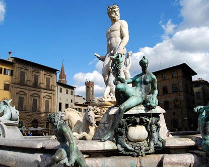 Fuente con múltiples estatuas de mármol blanco y bronce en plaza histórica