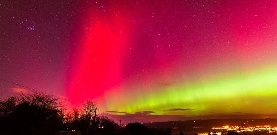 aurora boreal con cielo rojo, violeta y amarillo verdoso