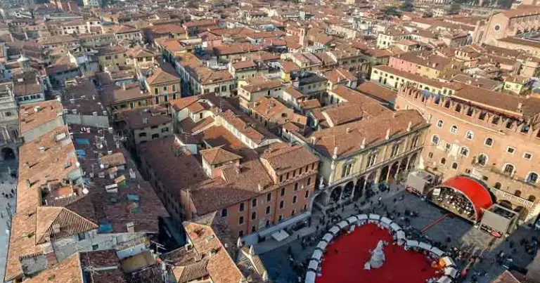 Vista aérea de ciudad medieval con tejados rojos y corazón rojo en plaza
