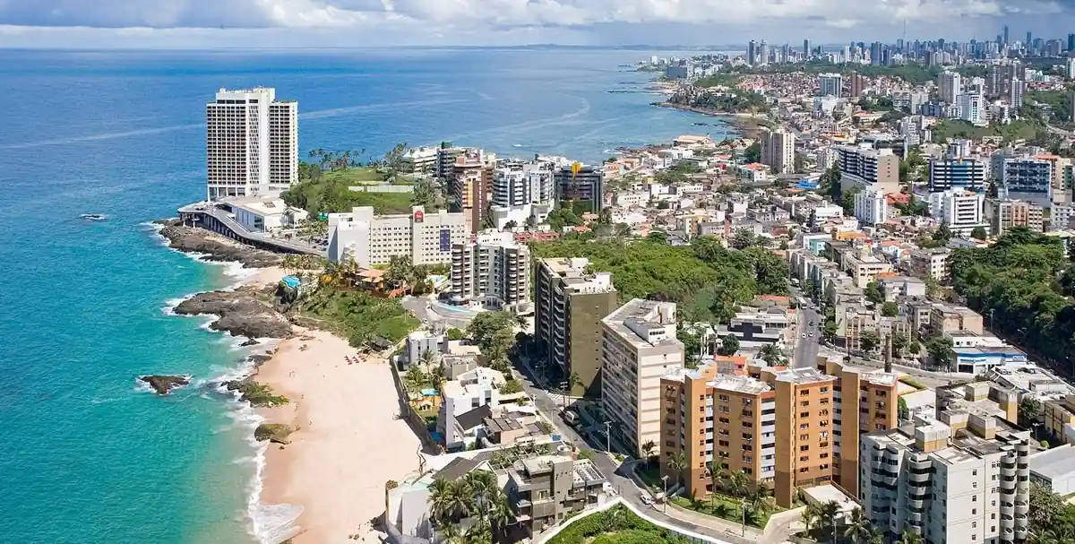 Vista aérea de costa urbana con playas, edificios y mar turqueso