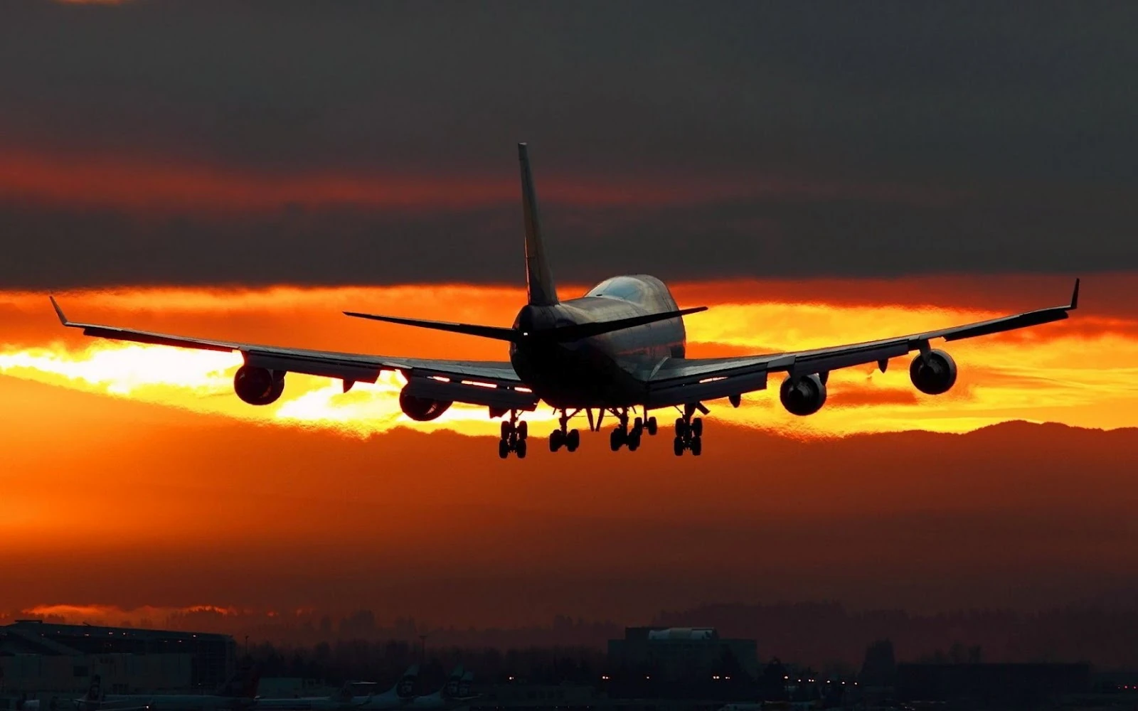 Avión en vuelo contra cielo anaranjado al atardecer