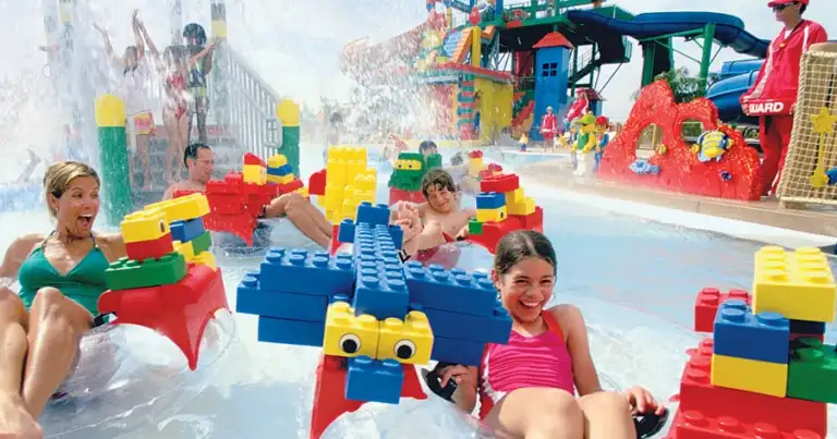Niños jugando con bloques LEGO gigantes en piscina de parque acuático
