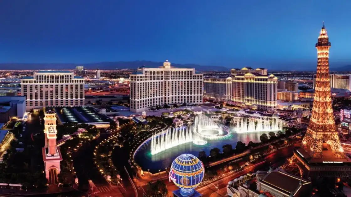 Vista aérea de Las Vegas iluminada al atardecer con casinos y la Torre Eiffel