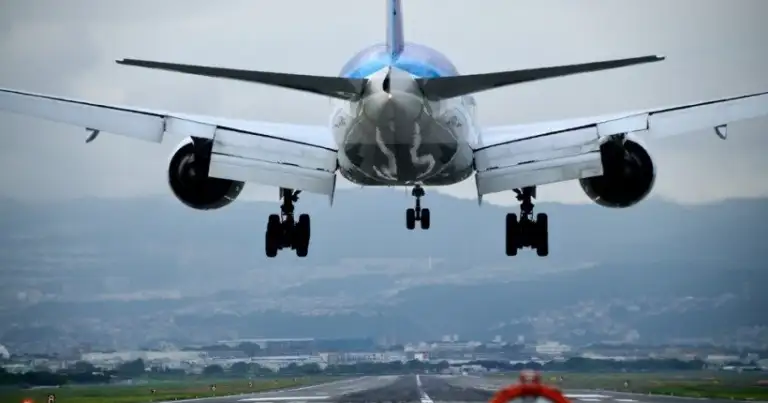 Avión en descenso visto de frente sobre llanuras con tren de aterrizaje bajado