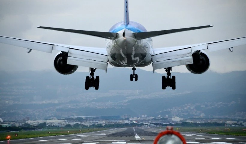 Avión en descenso visto de frente sobre llanuras con tren de aterrizaje bajado