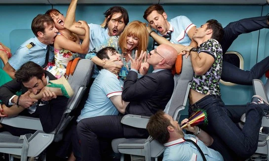 Grupo de pasajeros riendo y socializando en cabina de avión