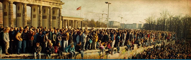 Multitud subida al Muro frente a la Puerta de Brandenburgo tras la apertura de la frontera en 1989
