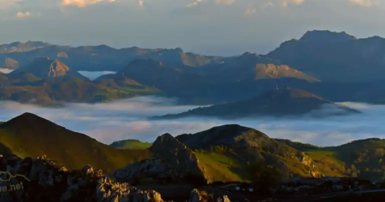 Montañas asturianas con un lago envuelto en niebla