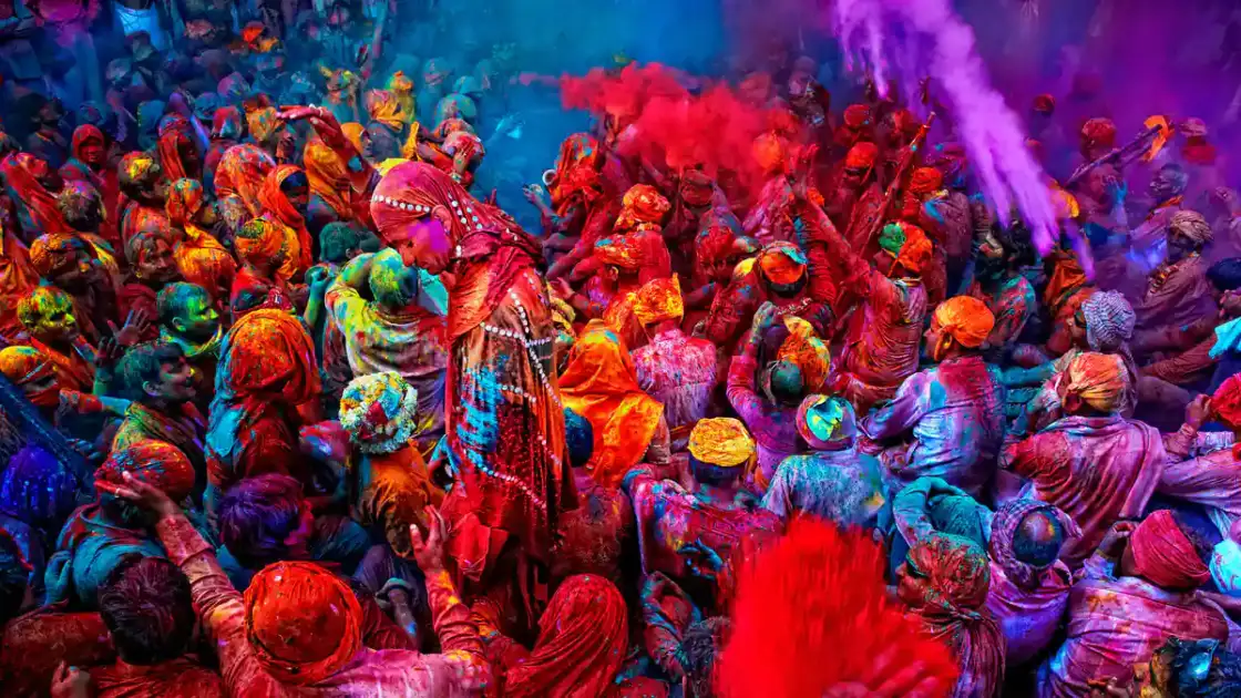 Multitud de personas cubiertas de polvos de colores brillantes en celebración