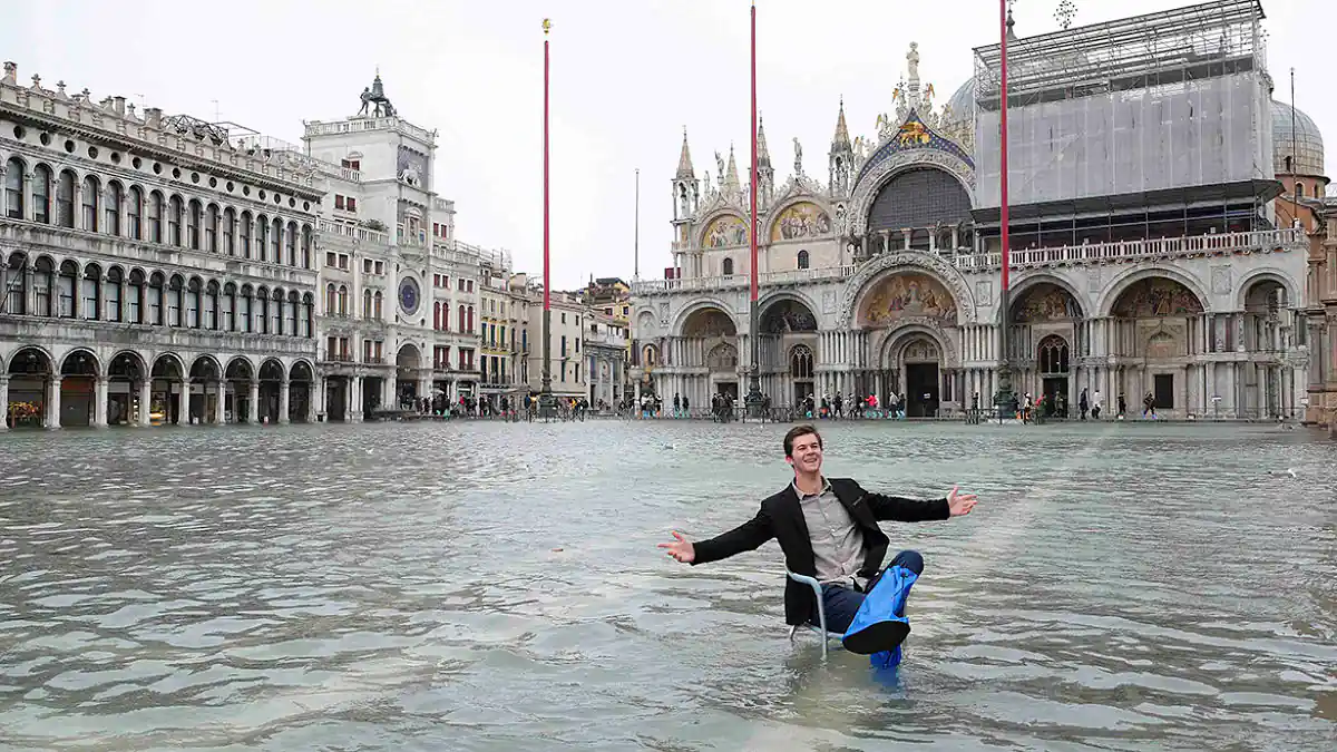 plaza San Marcos en Venecia inundada por la marea alta y un hombre flota en una silla