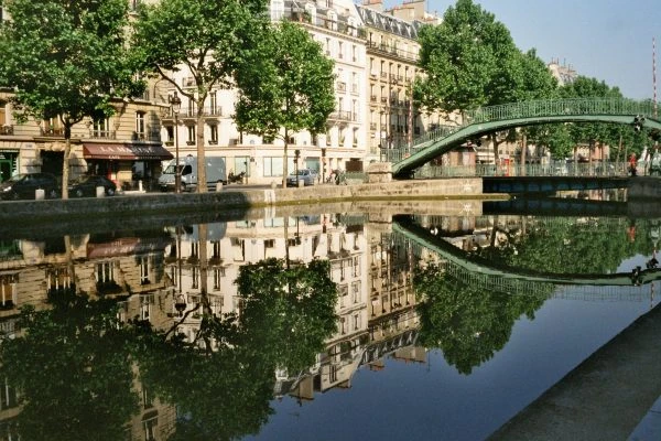 Canal urbano reflejando arquitectura circundante con puentes y árboles