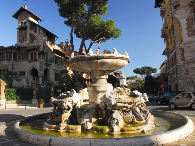 Fuente ornamental con esculturas doradas y edificios históricos