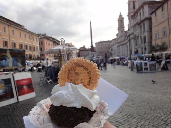 Helado con cobertura de chocolate en taza en plaza romana