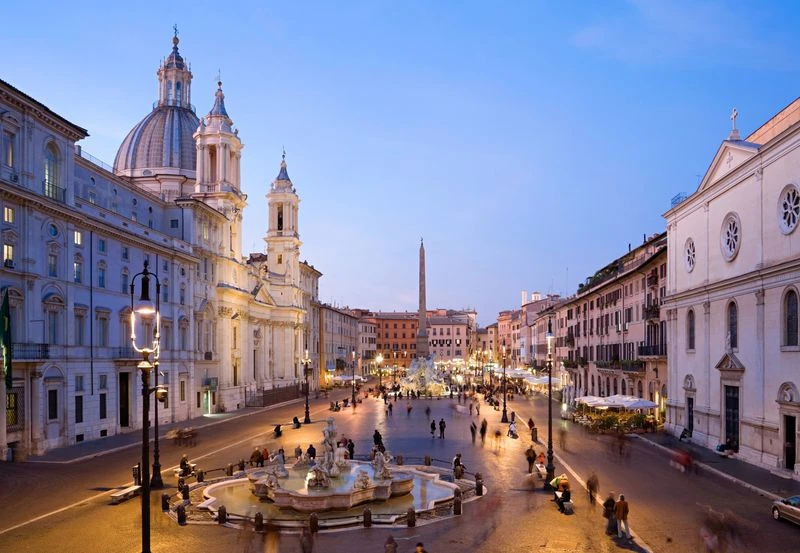 Piazza Navona en Roma de noche con iglesias y personas