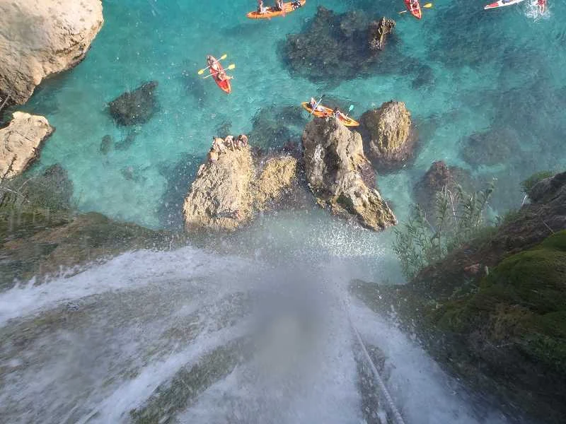 Cascada de Maro en Nerja con kayaks entre las rocas junto al mar