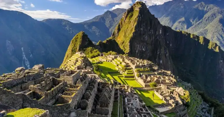 Ruinas incas en montaña con terrazas de piedra y picos rocosos al fondo