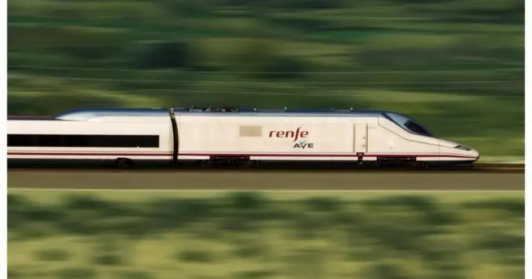 Tren de alta velocidad en movimiento entre vegetación verde borrosa