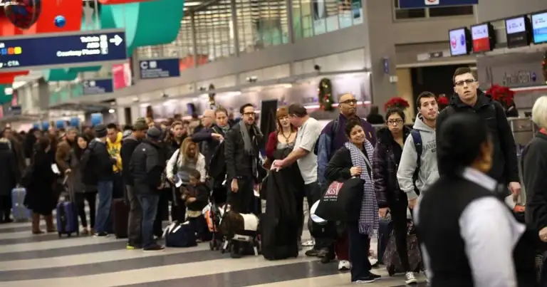 fila muy larga de pasajeros en mostradores de aereas