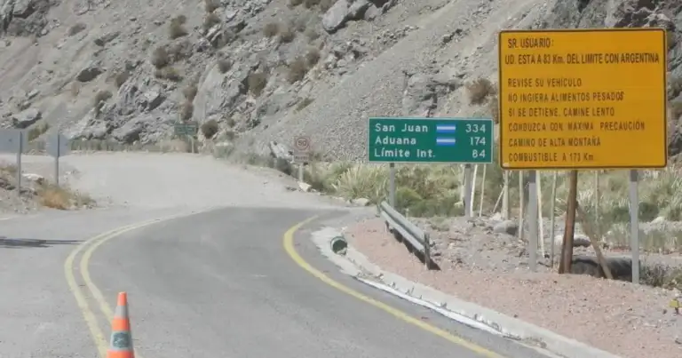 Carretera montañosa con señales de tránsito y paisaje árido