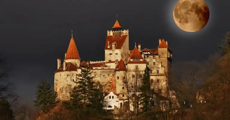 Castillo medieval con torres y luna llena en cielo nocturno