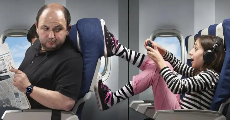 Pasajeros adultos en asientos de avión, uno leyendo periódico