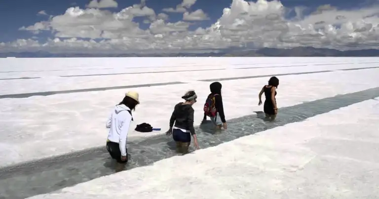 Cuatro personas caminando en salares blancos a gran altitud