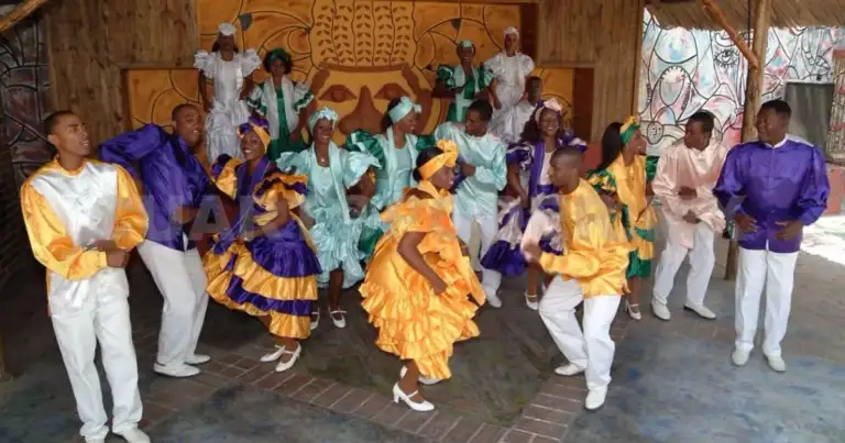 Personas en traje tradicional cubano bailando rumba en grupo