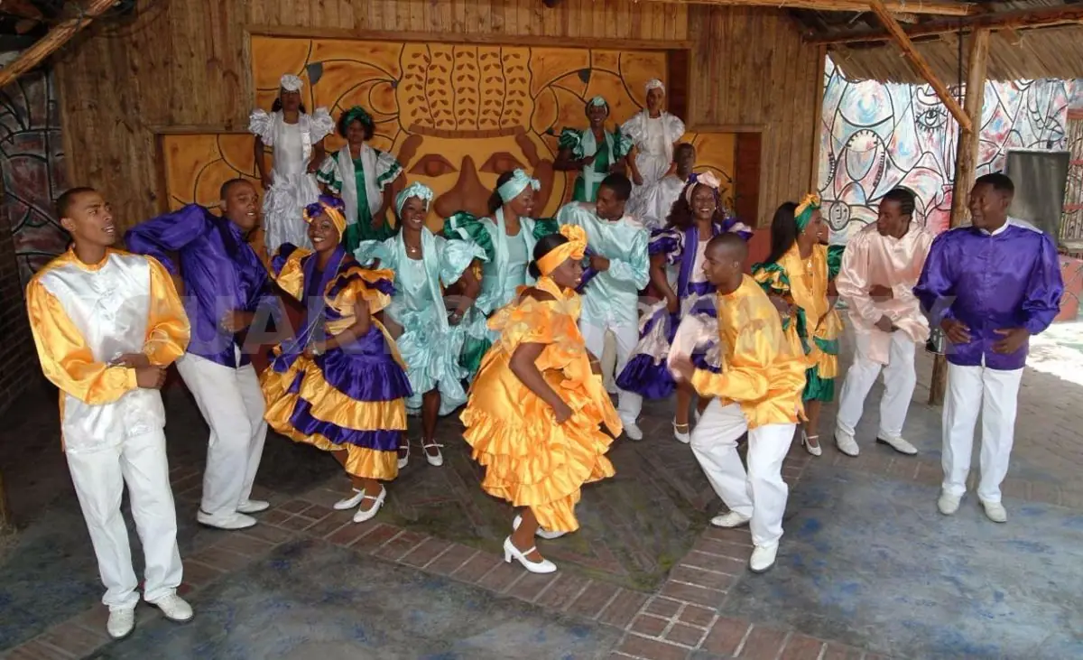Personas en traje tradicional cubano bailando rumba en grupo
