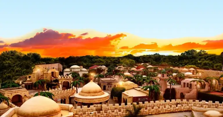 Montaña rocosa al atardecer con población de casas de adobe