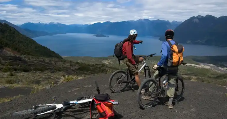 3 bicicletas con 3 personas en una parada del recorrido mirando un lago