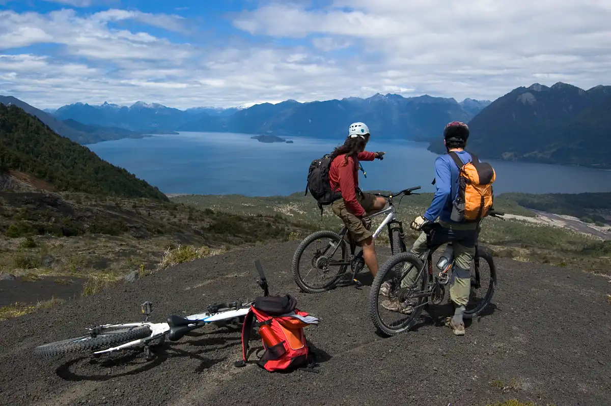 3 bicicletas con 3 personas en una parada del recorrido mirando un lago