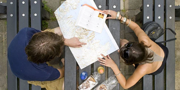 Dos viajeros observan un mapa sobre una mesa