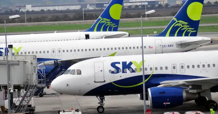 Aviones Sky Airline azul y amarillo estacionados en aeropuerto