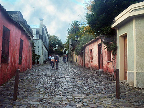 Calle empedrada colonial con edificios de colores en barrio histórico