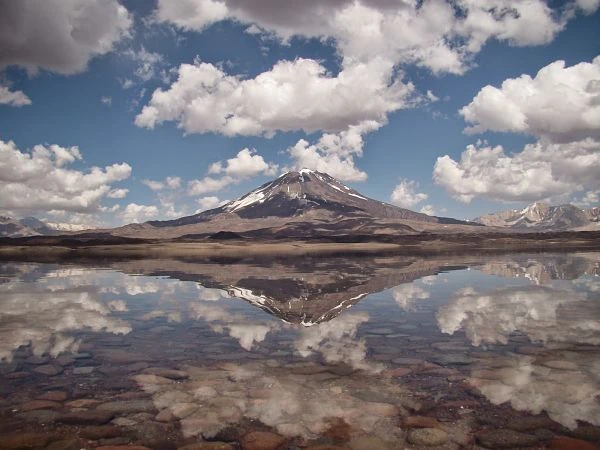 Volcán nevado con reflejo perfecto en laguna