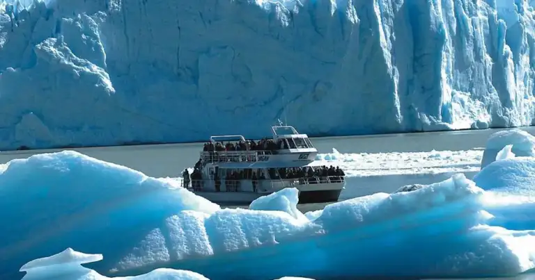 Barco turístico navegando entre témpanos de hielo frente a glaciar