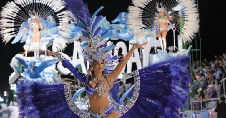 Danzarín en carnaval con atuendo azul, plumas blancas y tocado grande