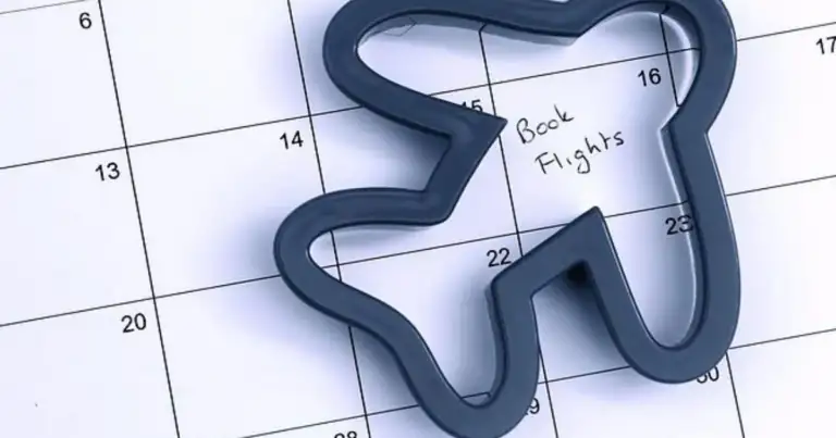 Marcador de viaje en forma de avión recortado sobre calendario