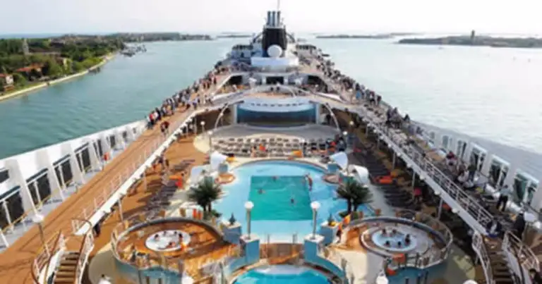 Cubierta de crucero con piscinas, jacuzzis y pasajeros disfrutando