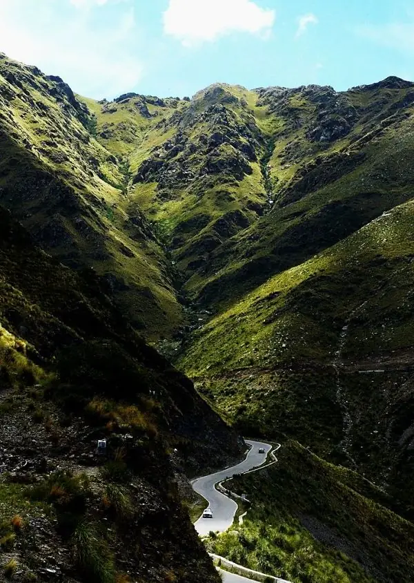 Valle verde montañoso con río y vegetación abundante