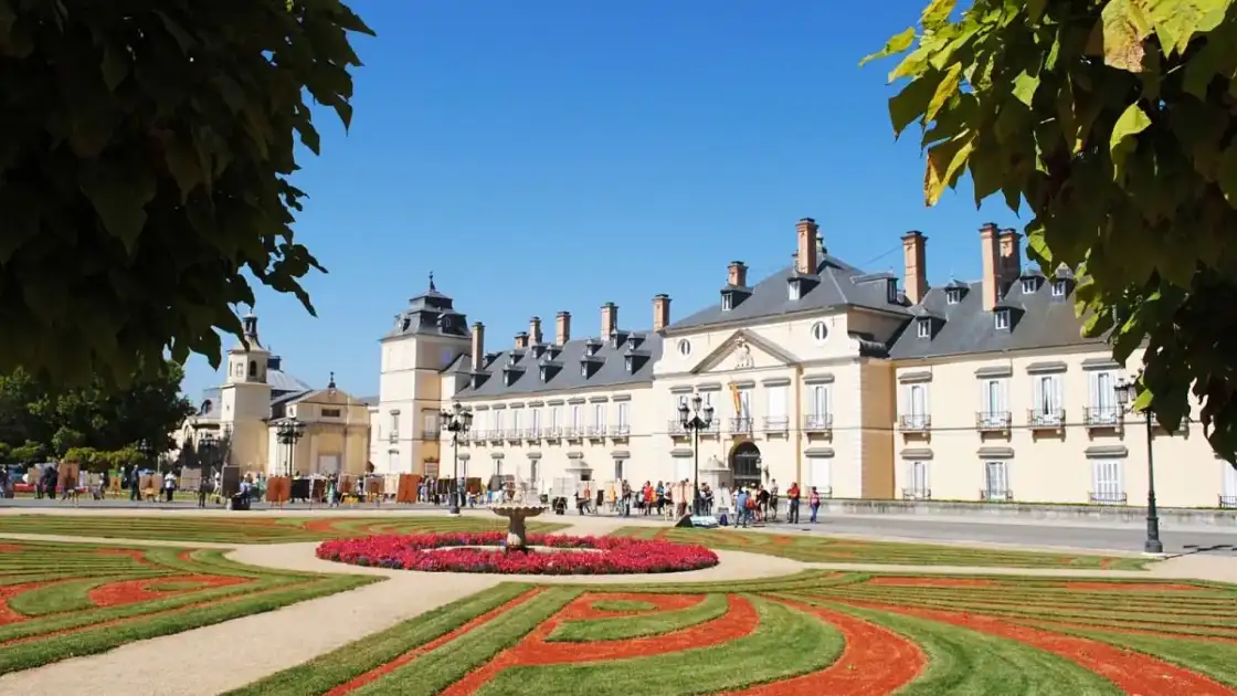 Palacio histórico blanco con jardines formales y camas de flores