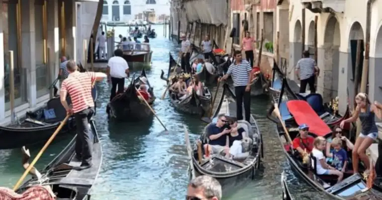Góndolas abarrotadas en un canal de Venecia con turistas