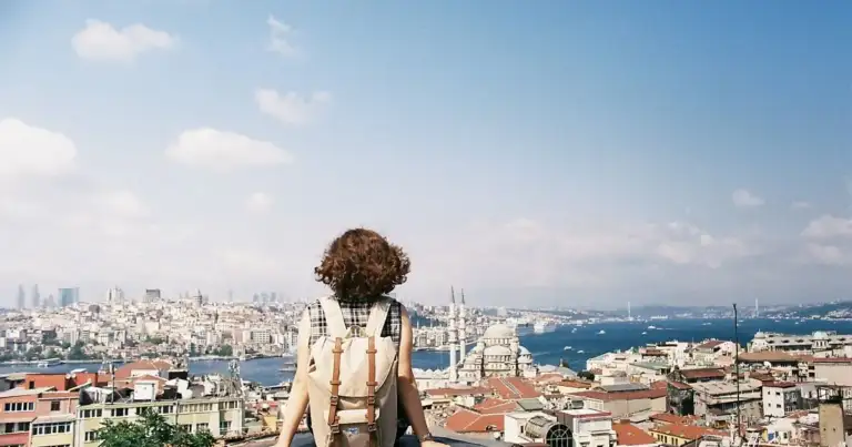 Persona mirando panorama de ciudad desde tejado elevado