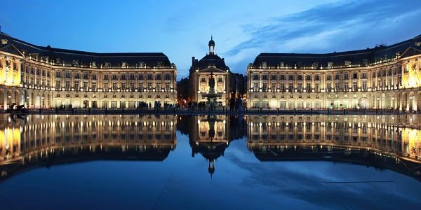 Plaza con edificios neoclásicos reflejados en agua tranquila