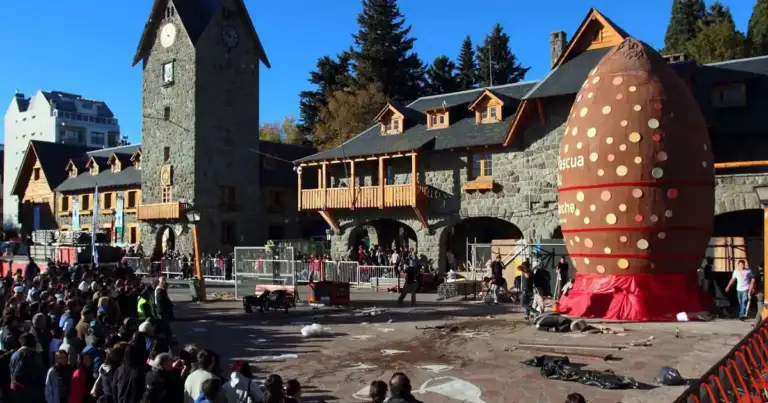 Centro turístico de Bariloche con arquitectura típica, multitud y escultura roja