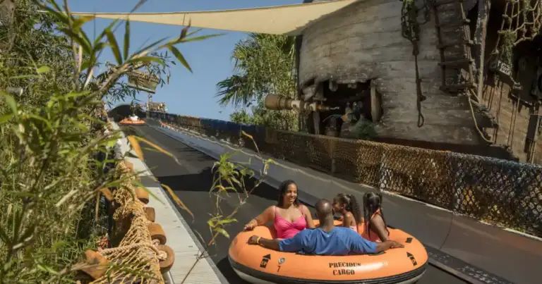Pasajeros en bote naranja en atracción acuática de Disney