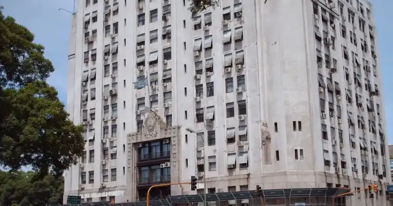 Edificio de oficinas de hormigón claro con muchas ventanas y andamios en la planta baja